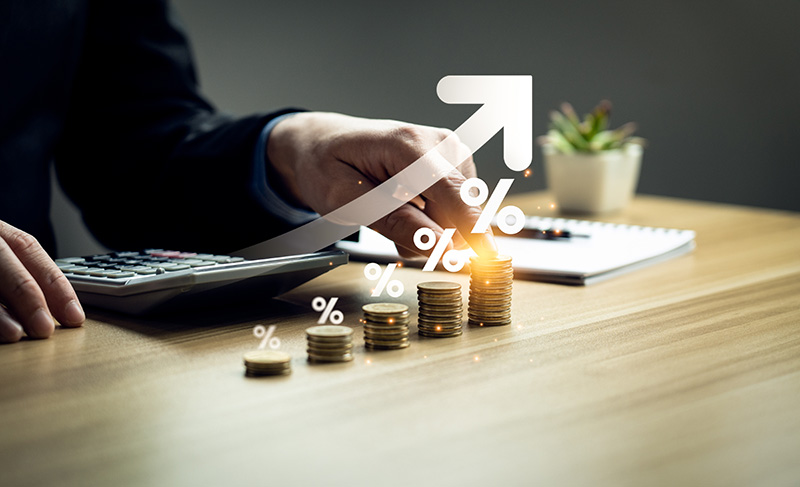 Man at desk with calculator and interest rate graphic