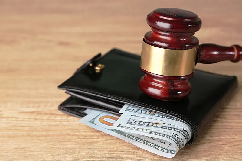 Gavel hitting a wallet full of money