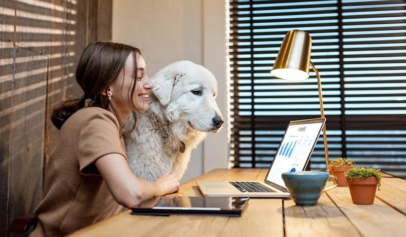 Lady hugging dog in her home office
