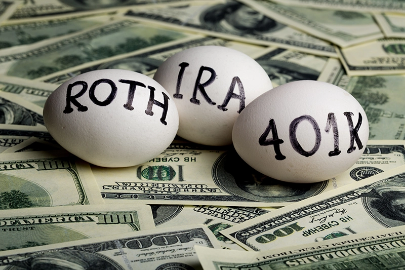 Roth, IRA, and 401K nest-eggs on a money background