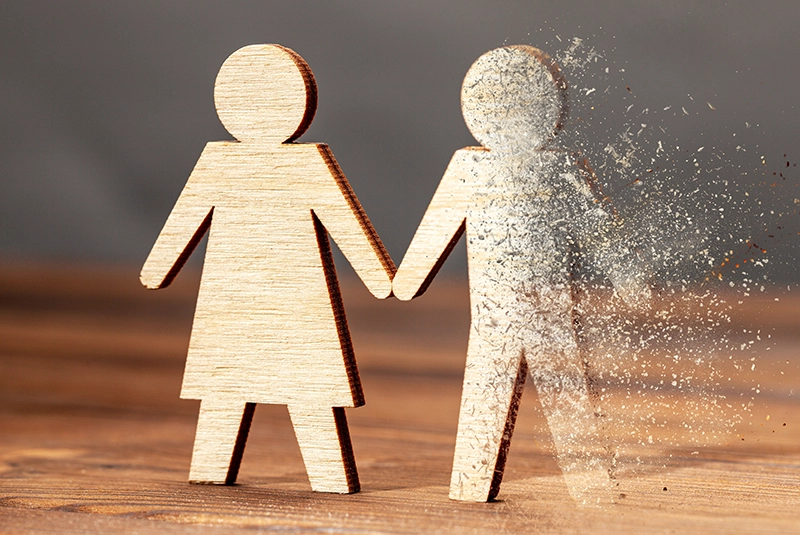 Wooden human shaped figures with the concept is dead husband - blowing ashes from deceased spouse.