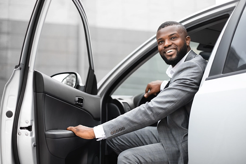 Man getting out of car wearing a business suit