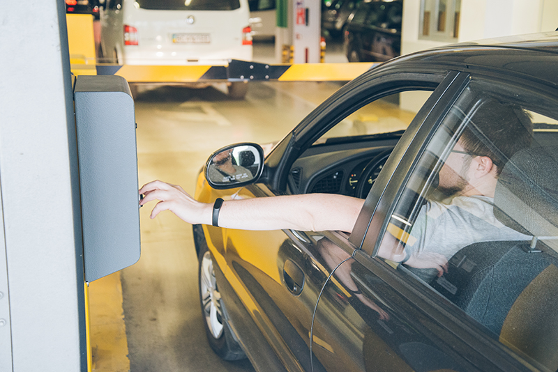 Man hitting button to enter parking structure