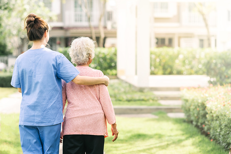 Nurse walking with elderly woman