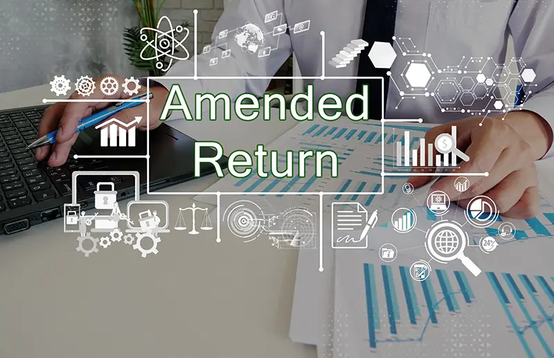 Amended Return written with man at computer and sheets of paper of graphs on them