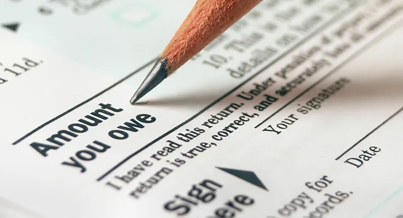 Pencil Pointing to "Amount you owe" wording on a tax return