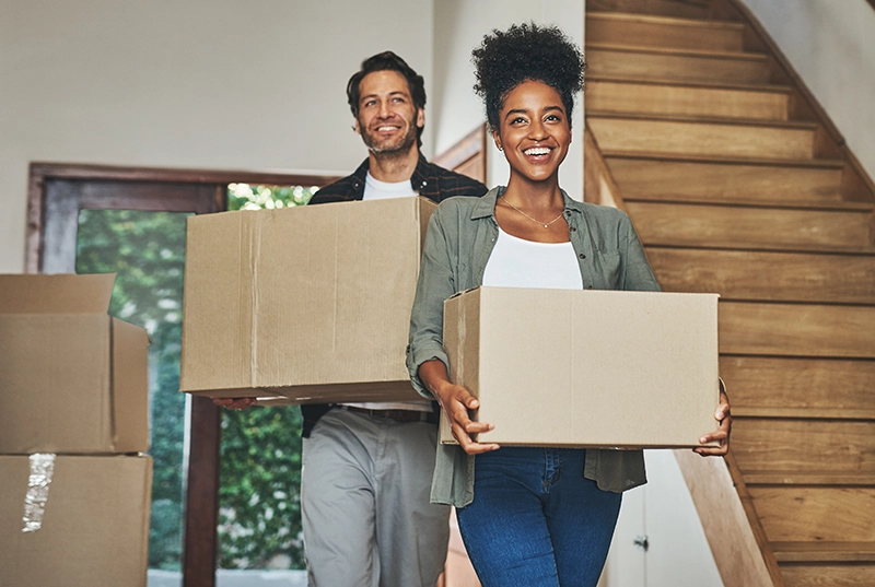 Couple holding moving boxes