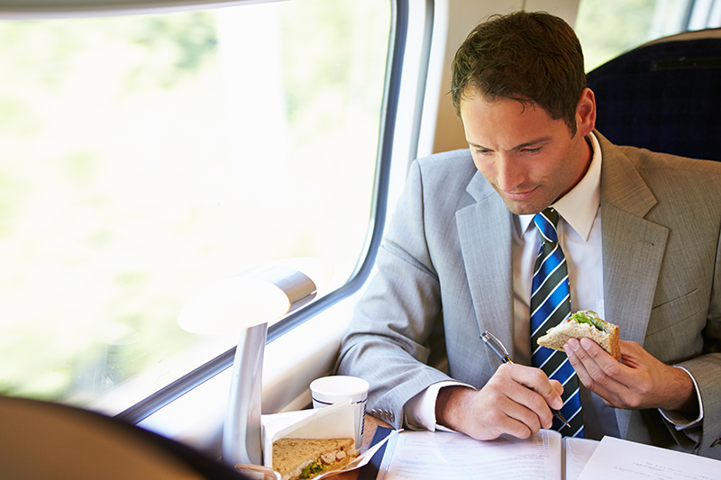 Man traveling for work while eating a sandwich